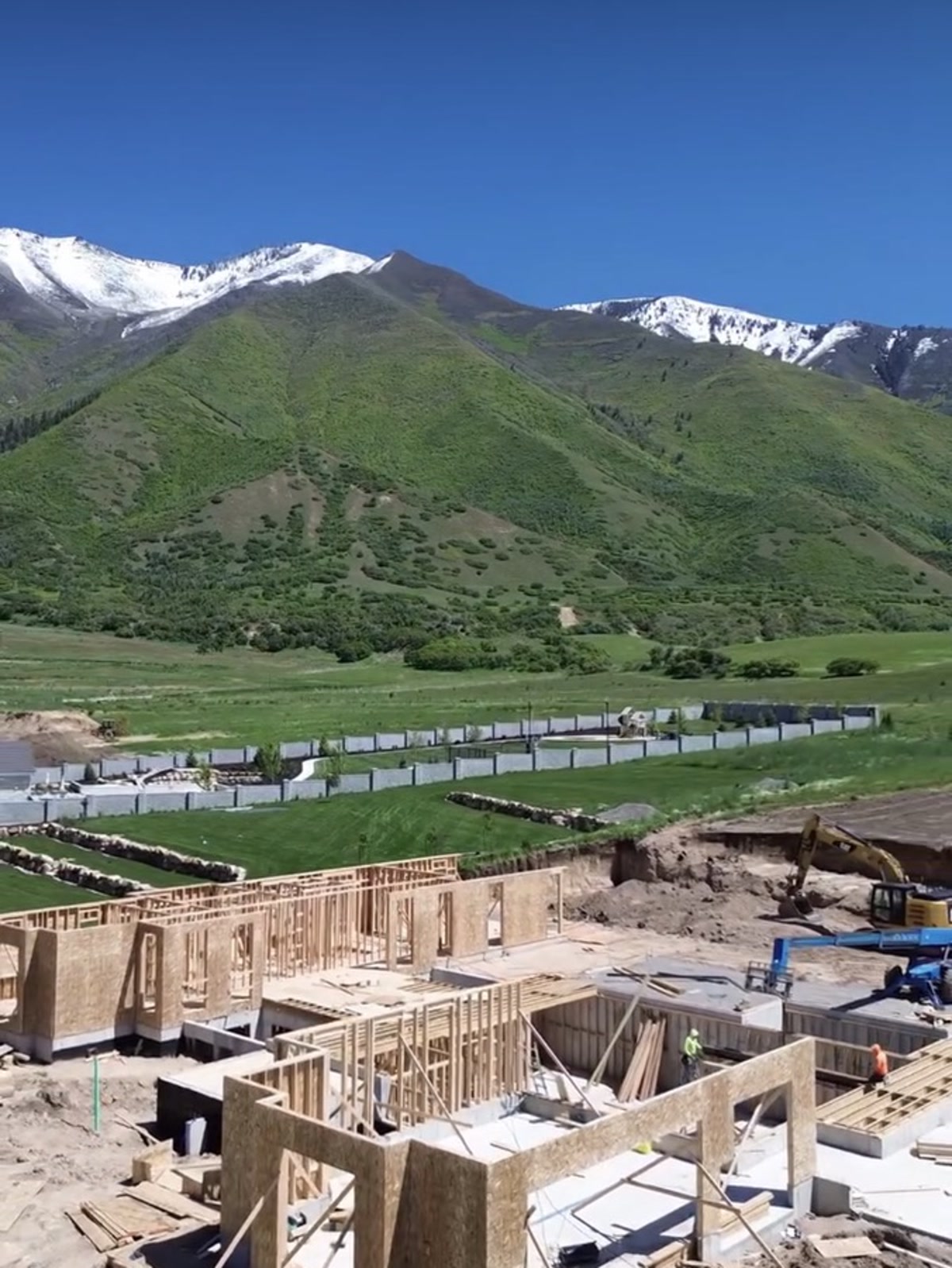 The framing crew at work with the mountains behind
